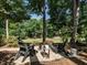 Backyard fire pit area has gravel, stone pavers, Adirondack chairs, and wooded views at 4716 Shadow Ridge Ct, Holly Springs, NC 27540