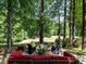 This backyard has stone patio, fire pit, comfortable seating, lush landscaping, and a serene setting at 4716 Shadow Ridge Ct, Holly Springs, NC 27540