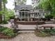 A gorgeous backyard boasts a large deck, screened porch, stone patio, and manicured landscaping at 4716 Shadow Ridge Ct, Holly Springs, NC 27540