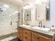 A spacious bathroom features a walk-in shower with marble tiles, a double sink vanity, and modern fixtures at 4716 Shadow Ridge Ct, Holly Springs, NC 27540