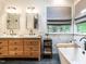 A bathroom with a double sink vanity, large soaking tub, marble tile accents, and a window with shades at 4716 Shadow Ridge Ct, Holly Springs, NC 27540