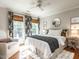 Bright bedroom featuring hardwood floors, ceiling fan, and decorative curtains at 4716 Shadow Ridge Ct, Holly Springs, NC 27540