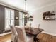 Formal dining room featuring hardwood floors, dark accent wall, and stylish light fixture at 4716 Shadow Ridge Ct, Holly Springs, NC 27540