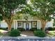Inviting community center entrance with lush landscaping, sidewalk, and a charming covered entryway at 4716 Shadow Ridge Ct, Holly Springs, NC 27540