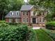Charming brick home with manicured landscaping, mature trees, and welcoming entrance at 4716 Shadow Ridge Ct, Holly Springs, NC 27540