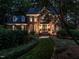 Stately brick home featuring manicured landscaping, illuminated entry, and inviting curb appeal at 4716 Shadow Ridge Ct, Holly Springs, NC 27540