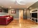 Spacious living room with hardwood floors, red sofa, and built-in shelves at 4716 Shadow Ridge Ct, Holly Springs, NC 27540