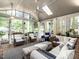 Screened porch featuring wicker furniture, ceiling fan, and skylights at 4716 Shadow Ridge Ct, Holly Springs, NC 27540