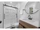 Bright bathroom showcasing a glass door shower, modern vanity, and round mirror at 5110 Old Well St, Durham, NC 27704