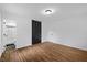 Spacious bedroom featuring wood floors, closet with black doors, and a light fixture at 5110 Old Well St, Durham, NC 27704