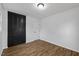 Bedroom featuring wood floors, closet with black doors, and a white door at 5110 Old Well St, Durham, NC 27704