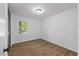 Cozy bedroom with a window allowing natural light and wood-look flooring at 5110 Old Well St, Durham, NC 27704