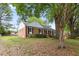 Brick home with manicured bushes and a covered porch at 5110 Old Well St, Durham, NC 27704