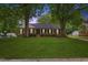 Charming brick home featuring a lush green lawn and mature trees at 5110 Old Well St, Durham, NC 27704
