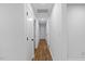 Bright hallway with white walls and trim leads to bedrooms and other areas of the home at 5110 Old Well St, Durham, NC 27704