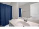 Bathroom featuring a single sink vanity, mirror, and bathtub with blue shower curtain at 512 Barneswyck Dr, Fuquay Varina, NC 27526