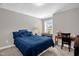 Bedroom features a blue comforter, desk with globe, and keyboard near a bright window at 512 Barneswyck Dr, Fuquay Varina, NC 27526