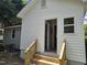 Back entrance with new stairs to a freshly painted house with white trim and vinyl siding at 605 E Montgomery St, Henderson, NC 27536