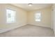 Bedroom features neutral carpet, base trim, and large windows at 605 E Montgomery St, Henderson, NC 27536
