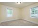 Bedroom features neutral carpet, base trim, and windows at 605 E Montgomery St, Henderson, NC 27536