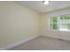 Bedroom features neutral carpet, base trim, and window at 605 E Montgomery St, Henderson, NC 27536