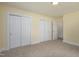 Bedroom features neutral carpet, base trim, and closets with doors at 605 E Montgomery St, Henderson, NC 27536