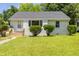 Charming single-story home with a well-maintained lawn and manicured bushes at 605 E Montgomery St, Henderson, NC 27536