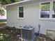 A new AC unit sits below a freshly painted house with white trim around the window at 605 E Montgomery St, Henderson, NC 27536