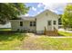 Back of the house with white brick and siding, access door, and stairs at 605 E Montgomery St, Henderson, NC 27536