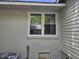 Exterior side of a house featuring fresh paint, white trim, and green treetop reflections in window at 605 E Montgomery St, Henderson, NC 27536