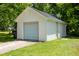 Close-up of the detached garage, highlighting its white siding, black roof, and single-car garage door at 605 E Montgomery St, Henderson, NC 27536