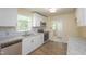 Modern kitchen featuring stainless steel appliances, granite countertops, and white cabinetry at 605 E Montgomery St, Henderson, NC 27536