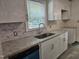 Kitchen featuring white cabinets, granite countertops, and a stainless steel sink at 605 E Montgomery St, Henderson, NC 27536