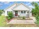 Adorable single-story home showcasing a welcoming porch, colorful flower beds, and charming curb appeal at 606 Arden St, Burlington, NC 27215