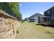 Large backyard with a retaining wall and black fence, perfect for outdoor activities and privacy at 609 Ramsours Mill Dr, Holly Springs, NC 27540