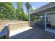 Wide angle view of the covered screened in patio area, adjacent to a wooden deck at 609 Ramsours Mill Dr, Holly Springs, NC 27540