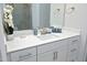 Bathroom vanity featuring white cabinetry, brushed nickel hardware and decor, with a tiled glass shower in the background at 609 Ramsours Mill Dr, Holly Springs, NC 27540