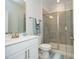 Modern bathroom featuring a glass enclosed shower, white vanity, and sleek gray tile at 609 Ramsours Mill Dr, Holly Springs, NC 27540
