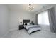 Bedroom with neutral carpeting, natural light, contemporary light fixture, and a dark wood bed frame at 609 Ramsours Mill Dr, Holly Springs, NC 27540