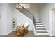 Inviting entryway with hardwood floors, stairs with iron railings, and a decorative rocking chair at 609 Ramsours Mill Dr, Holly Springs, NC 27540
