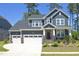 Beautiful two-story home with a three-car garage, stone accents, and a well-manicured lawn at 609 Ramsours Mill Dr, Holly Springs, NC 27540