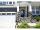 Inviting front porch with stone steps and decorative flower boxes, leading to a stylish front door at 609 Ramsours Mill Dr, Holly Springs, NC 27540