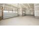 Spacious unfinished three car garage with high ceilings, windows, and concrete floor at 609 Ramsours Mill Dr, Holly Springs, NC 27540