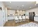 Bright kitchen with white cabinets, stainless steel appliances, a large island, and pendant lighting at 609 Ramsours Mill Dr, Holly Springs, NC 27540