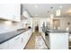 Modern kitchen with stainless steel appliances, grey countertops, white cabinetry, and a central island at 609 Ramsours Mill Dr, Holly Springs, NC 27540