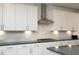 Kitchen with white cabinets, stainless steel appliances, and a gray marble backsplash at 609 Ramsours Mill Dr, Holly Springs, NC 27540