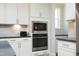 Kitchen featuring stainless steel microwave and oven with white cabinetry at 609 Ramsours Mill Dr, Holly Springs, NC 27540