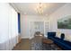 Cozy living room with a blue sofa, chandelier, and French doors leading to another room at 609 Ramsours Mill Dr, Holly Springs, NC 27540