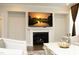 Living room with fireplace and television showing a landscape scene, decorated with white furniture at 609 Ramsours Mill Dr, Holly Springs, NC 27540