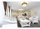 Bright living room with elegant white furniture, decorative chandelier and open access to the modern kitchen at 609 Ramsours Mill Dr, Holly Springs, NC 27540